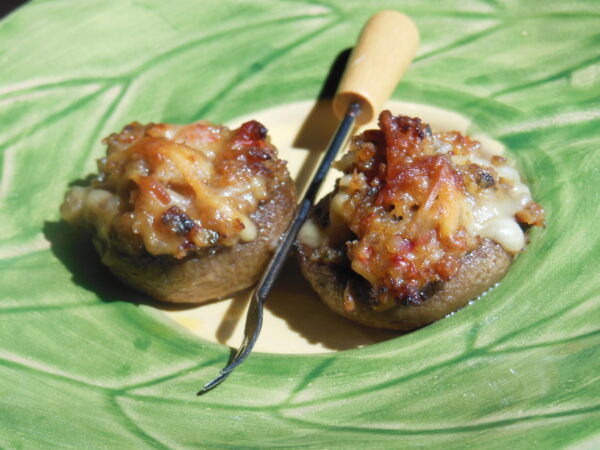 two stuffed mushrooms on plate with fork