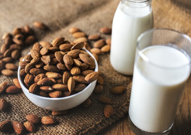 bowl of almonds with almonds on table beside milk